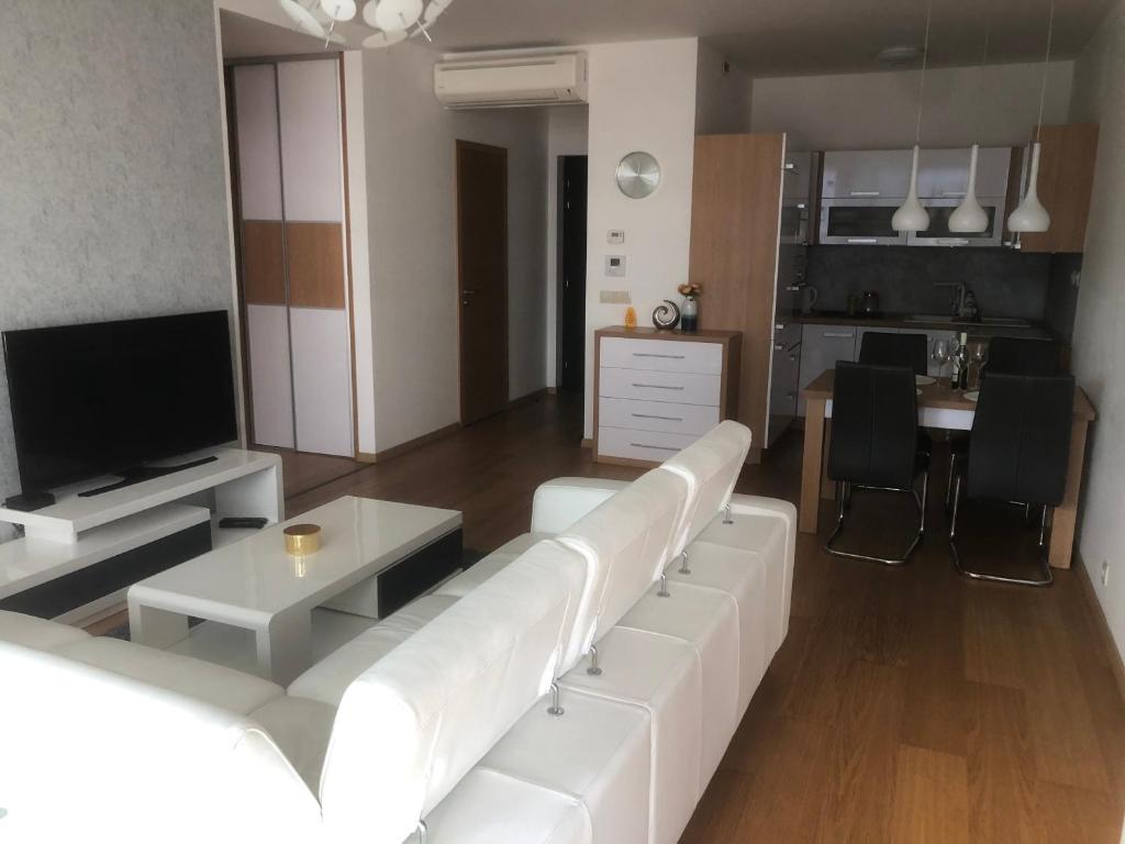 sala de estar con sofá blanco y TV en Apartmán v centre, 4os., parking, en Bratislava
