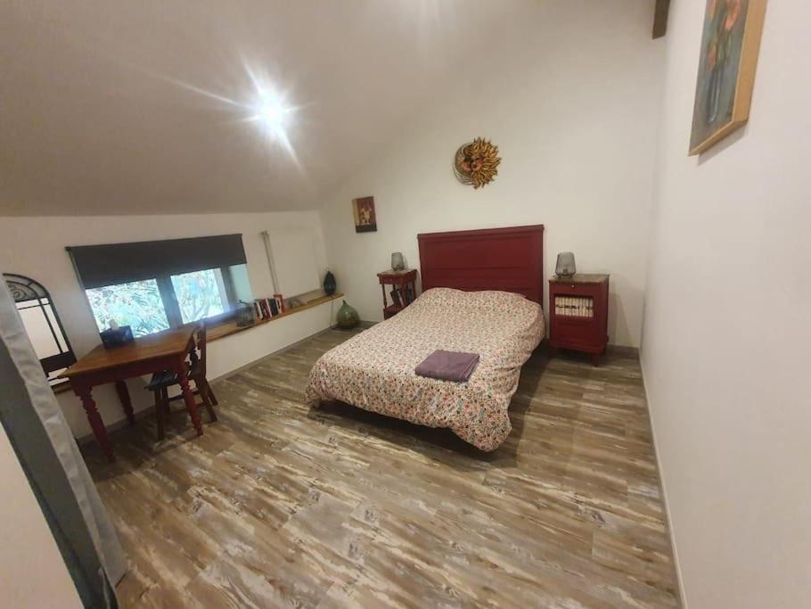 une chambre avec un lit, une table et un bureau dans l'établissement chambre indépendante, à Marboz