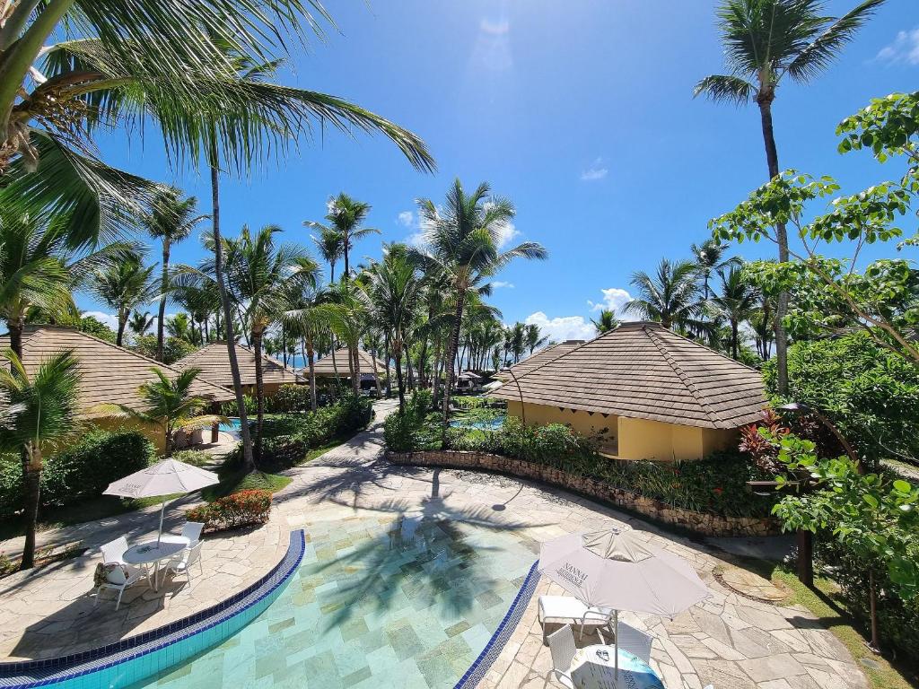 ein Resort mit Swimmingpool und Palmen in der Unterkunft Nannai Residence Muro Alto Porto de Galinhas por Brevelar in Porto De Galinhas