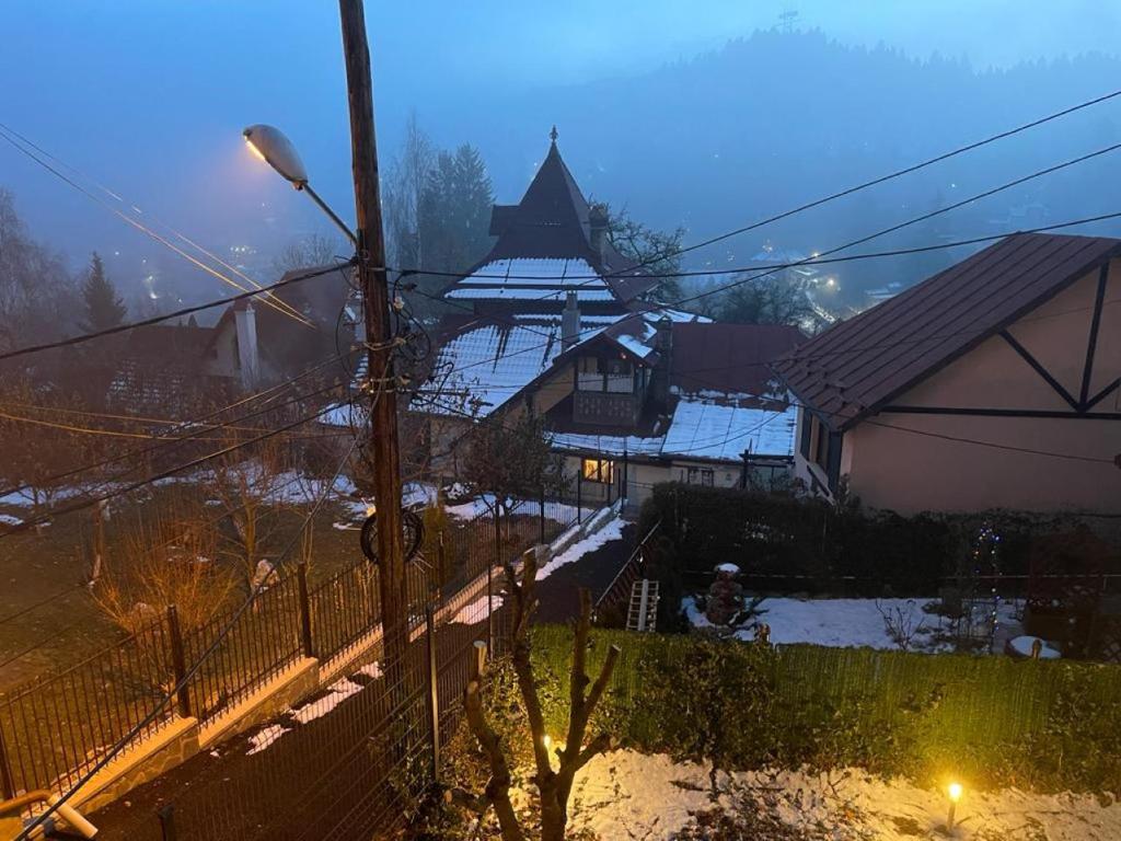 a view of a house with snow on the ground at Apartament Atoosa cu vedere la munte in Sinaia