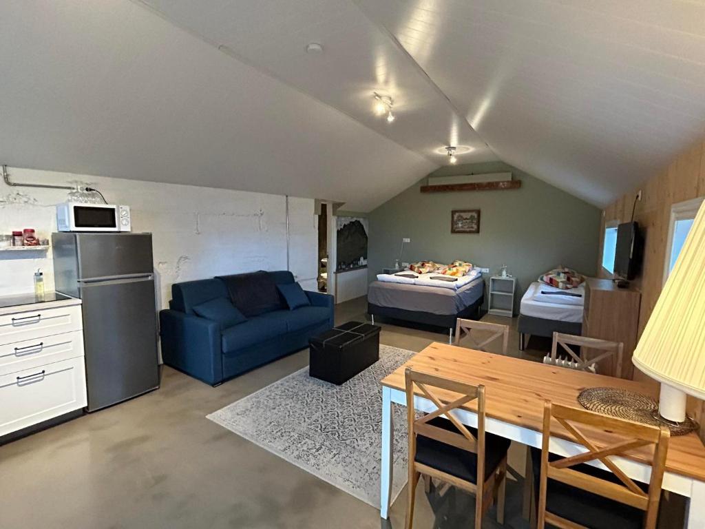 Apartment for 4 guests في هفولسفولر: غرفة معيشة مع أريكة زرقاء ومطبخ