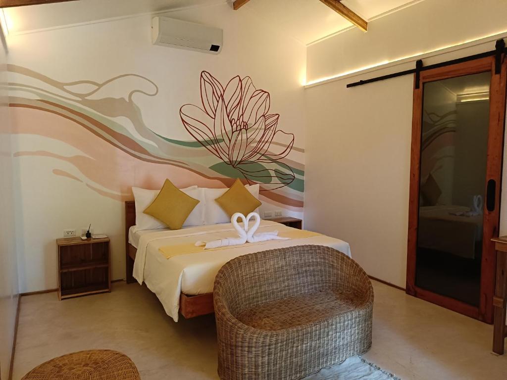 a bedroom with a bed with a flower mural on the wall at Kawai Duli Bungalows in El Nido