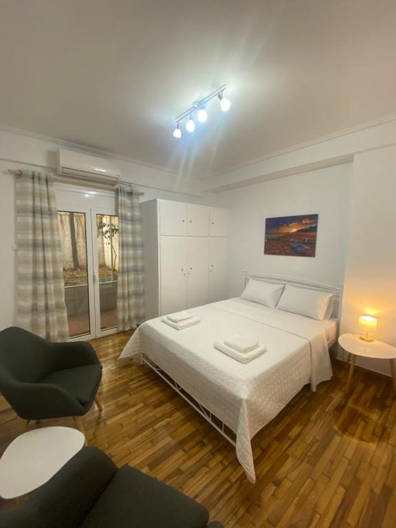 um quarto com uma grande cama branca e uma cadeira em Domna Home Next To Sigrou Avenue em Atenas