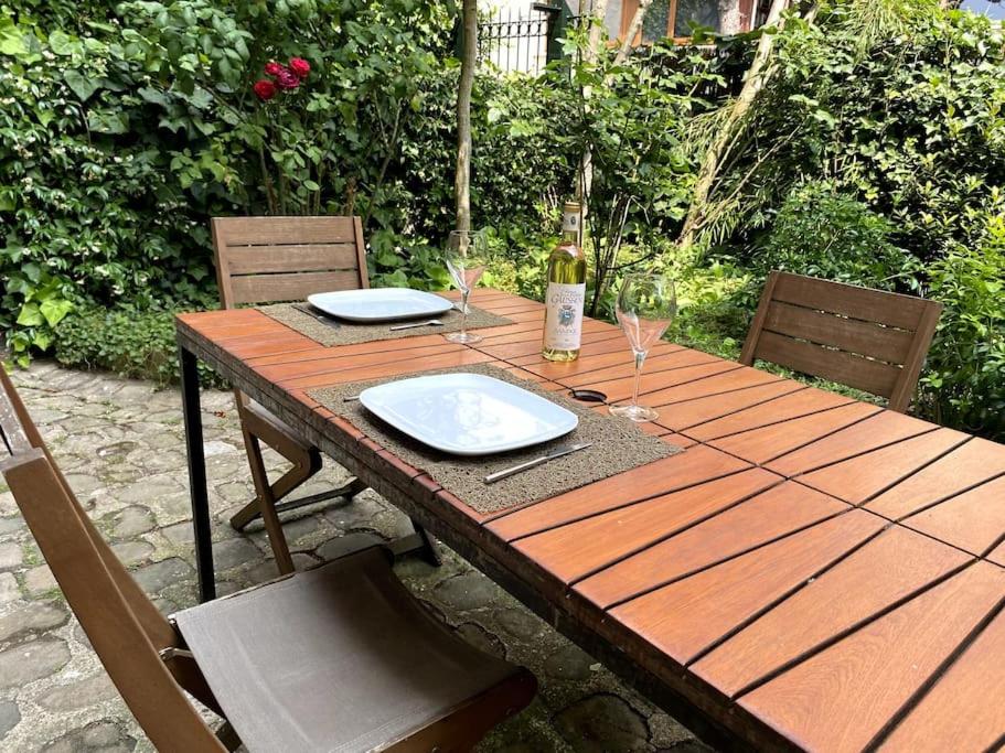 une table en bois avec des assiettes et des verres à vin dessus dans l'établissement Tour Eiffel - Appartement avec jardin, à Paris