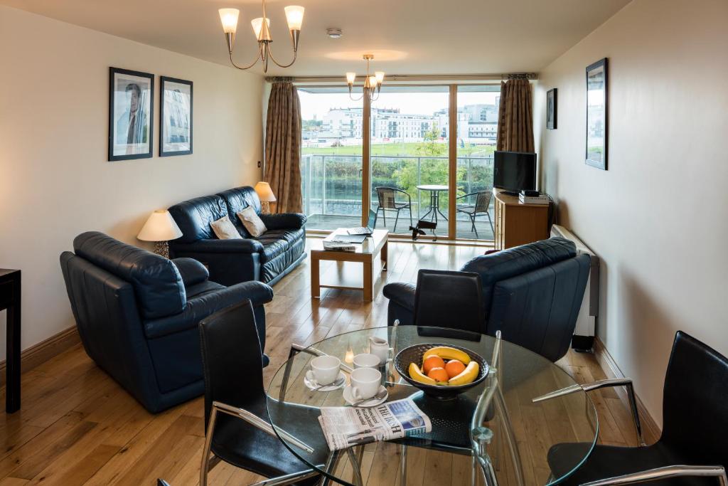 een woonkamer met een tafel en stoelen bij Fitzwilliam Point in Dublin