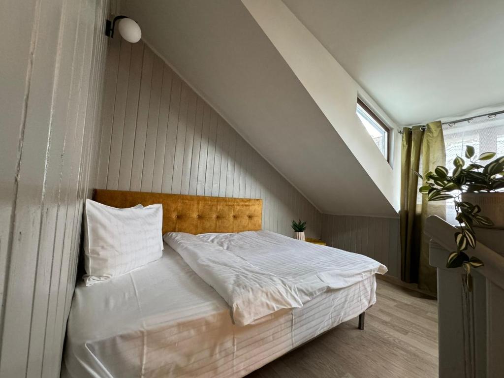 een slaapkamer met een bed met witte lakens en een raam bij Central Stay Brasov in Braşov