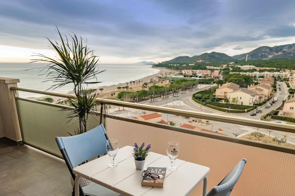 una mesa y sillas con vistas al océano en Apartamento con terraza, vistas playa y montaña en Hospitalet de l'Infant