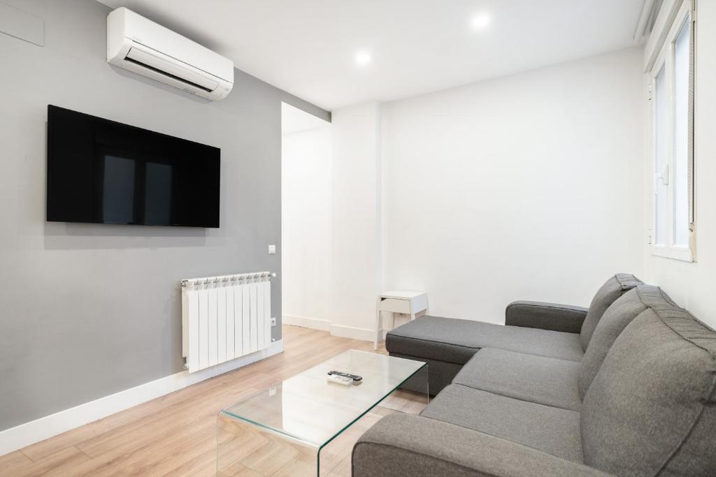sala de estar con sofá y TV en apartamento exclusivo en velazquez en Madrid