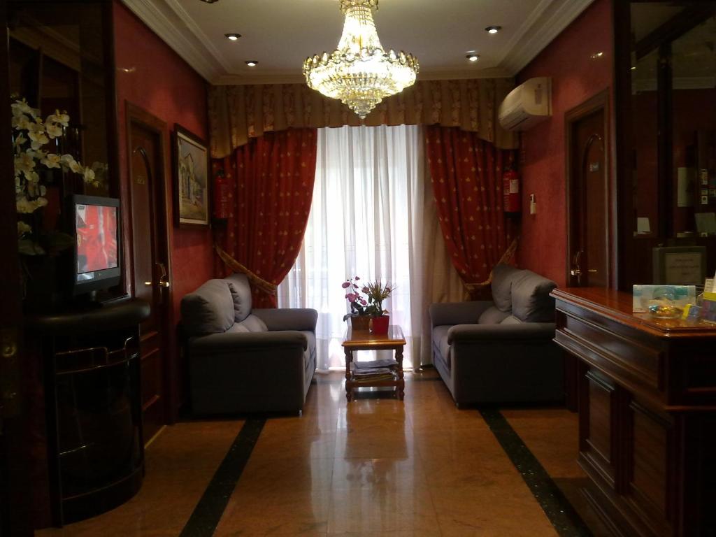 una sala de estar con 2 sofás y una lámpara de araña. en Hostal Centro Sol Madrid, en Madrid