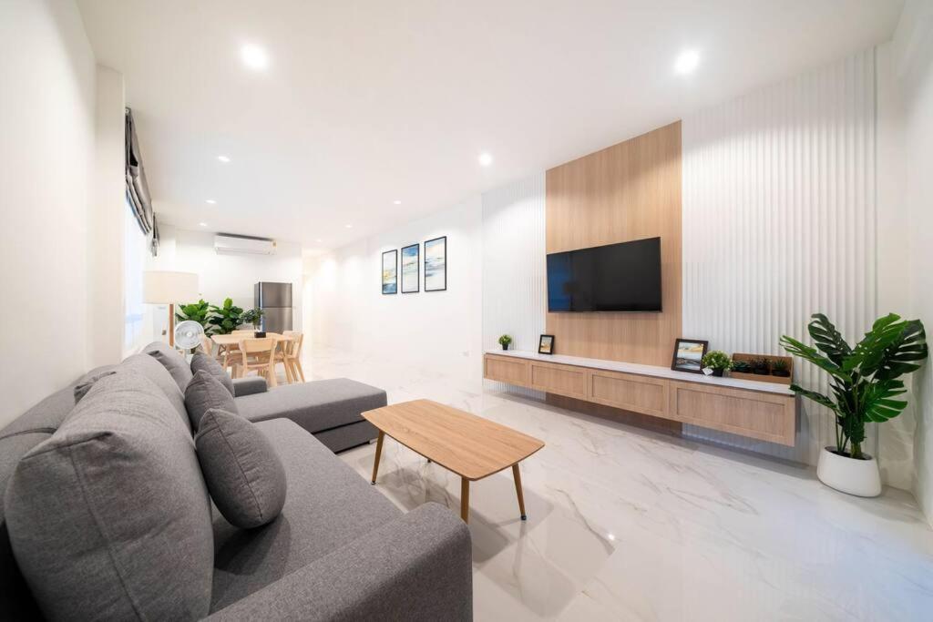 uma sala de estar com um sofá, uma televisão e uma mesa em New 2BR townhome 350M walk to kata beach em Praia de Kata