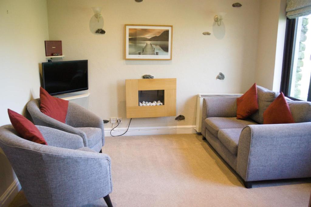 a living room with two couches and a fireplace at Grisdale View in Penrith