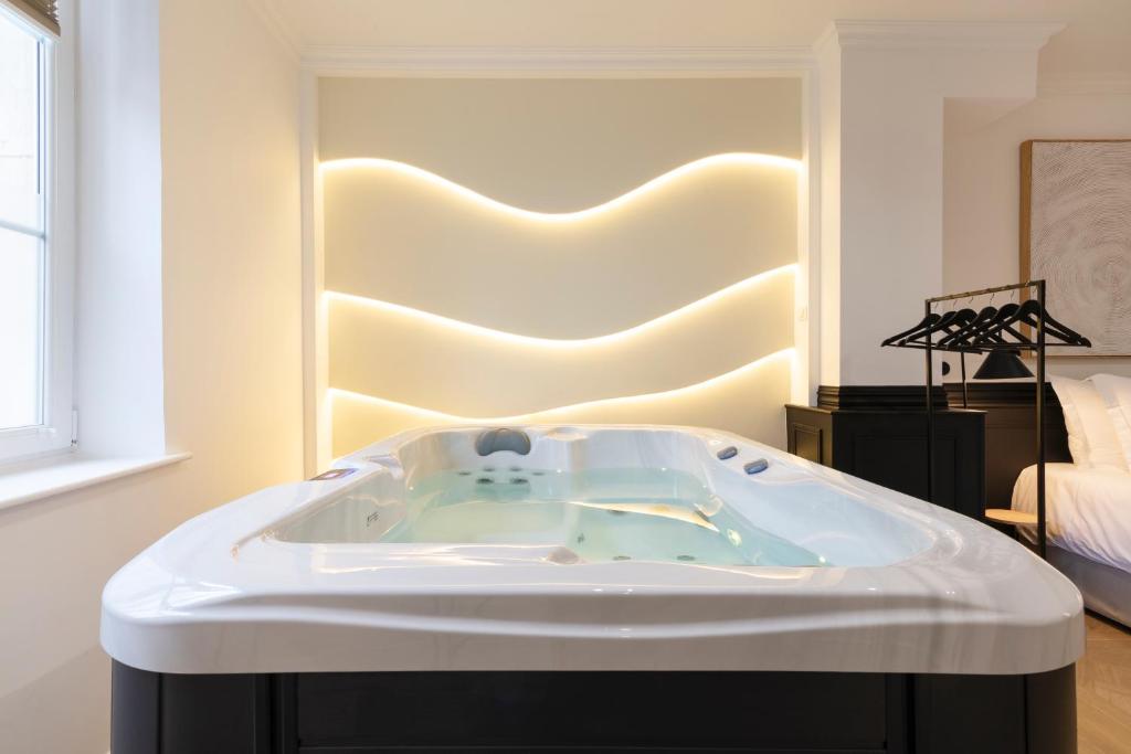 a bath tub in a room with a bed at Le Rêve de Stanislas - Jacuzzi in Nancy