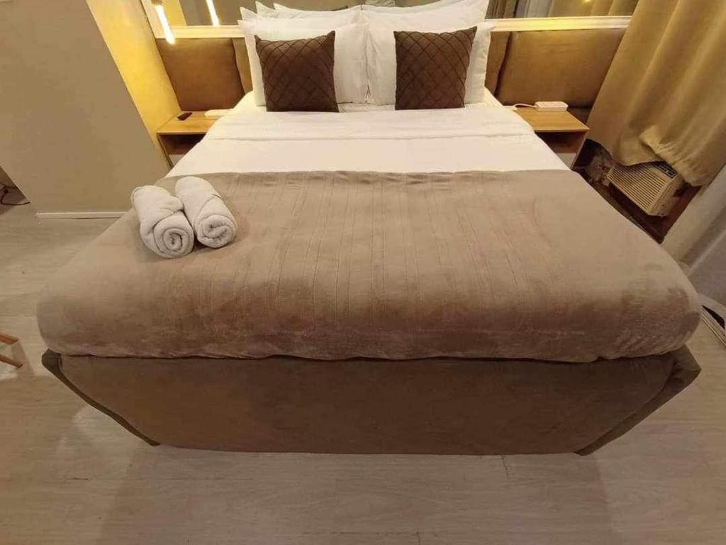een slaapkamer met een groot bed en handdoeken bij Citadel Inn A2 Makati Central Nightlife in Manilla