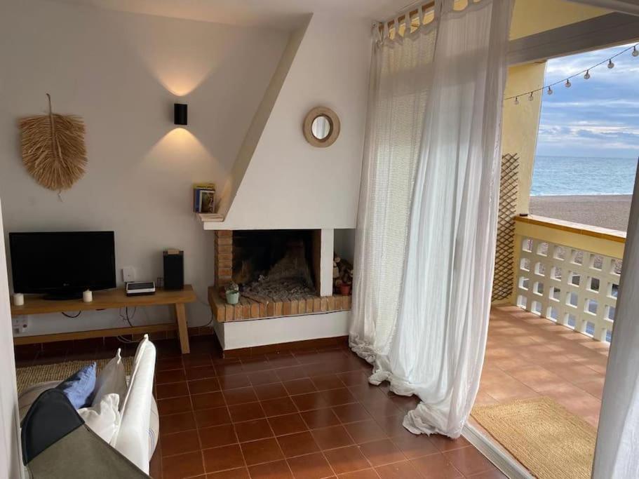 una sala de estar con chimenea y el océano en Costa Brava Beach House, en Begur