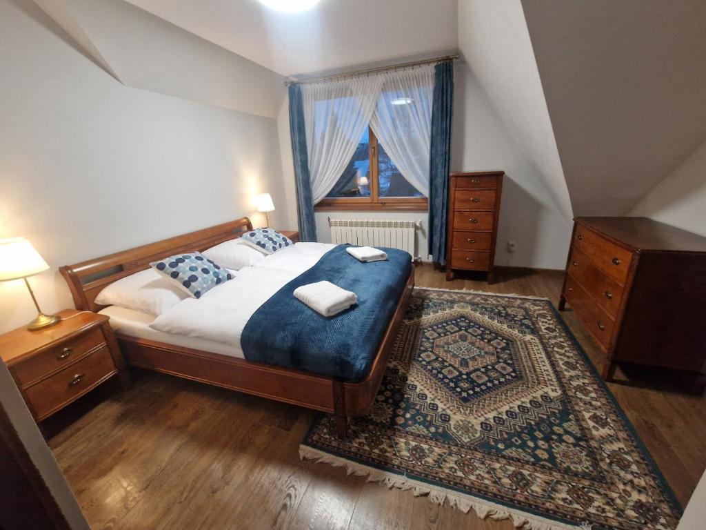a bedroom with a large bed and a window at Apartamenty Monti in Bukowina Tatrzańska