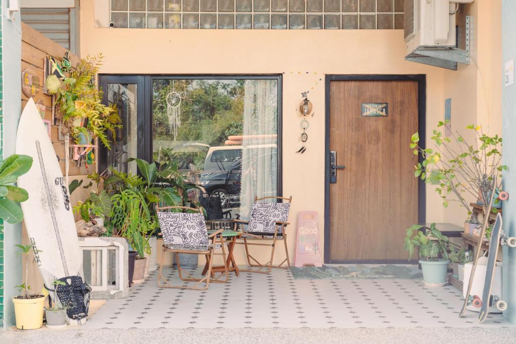 una puerta delantera de una casa con sillas y mesa en Good Trip Hostel 菇憩民宿, en Hengchun
