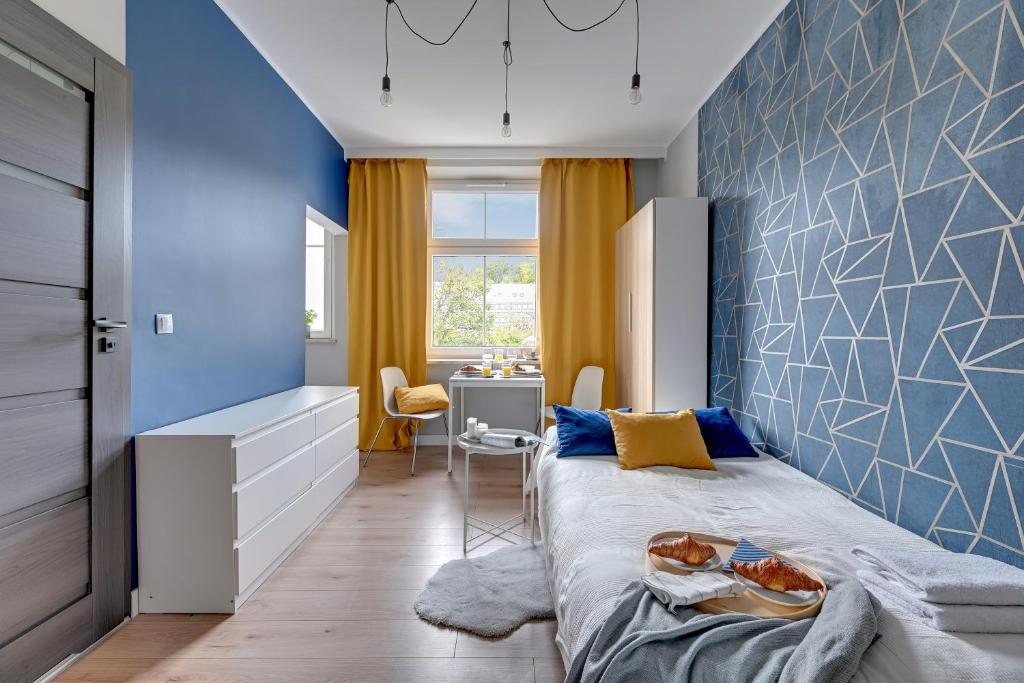 a bedroom with a bed with a blue wall at Gdynia Stacja 24/7 in Gdynia