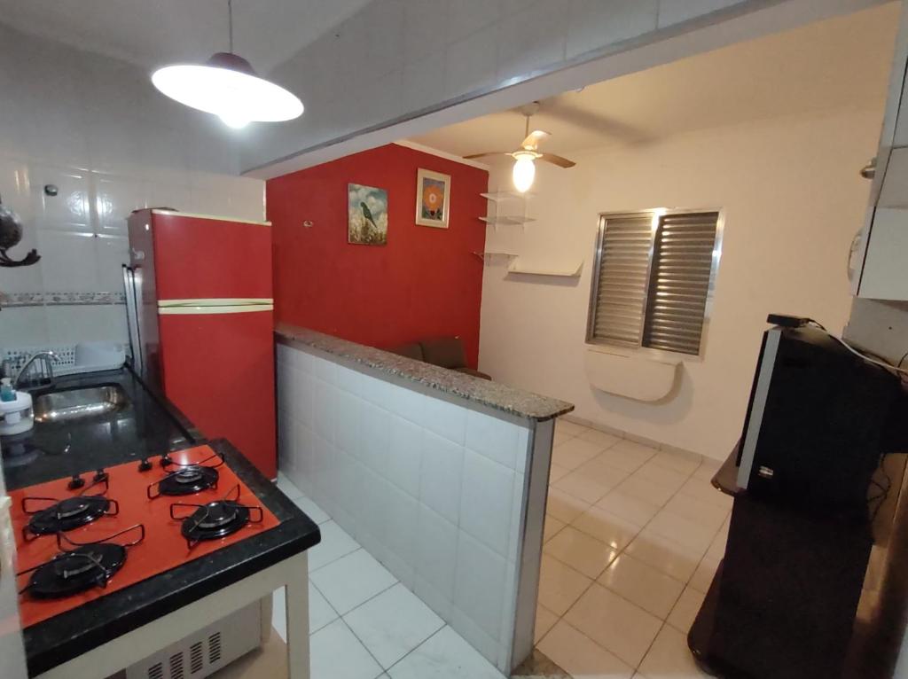 a kitchen with a red stove and a red refrigerator at Kitnet Praia Grande in Praia Grande