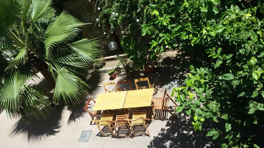レッジョ・ディ・カラブリアにあるDef Houseの椅子とヤシの木がある家の頭上