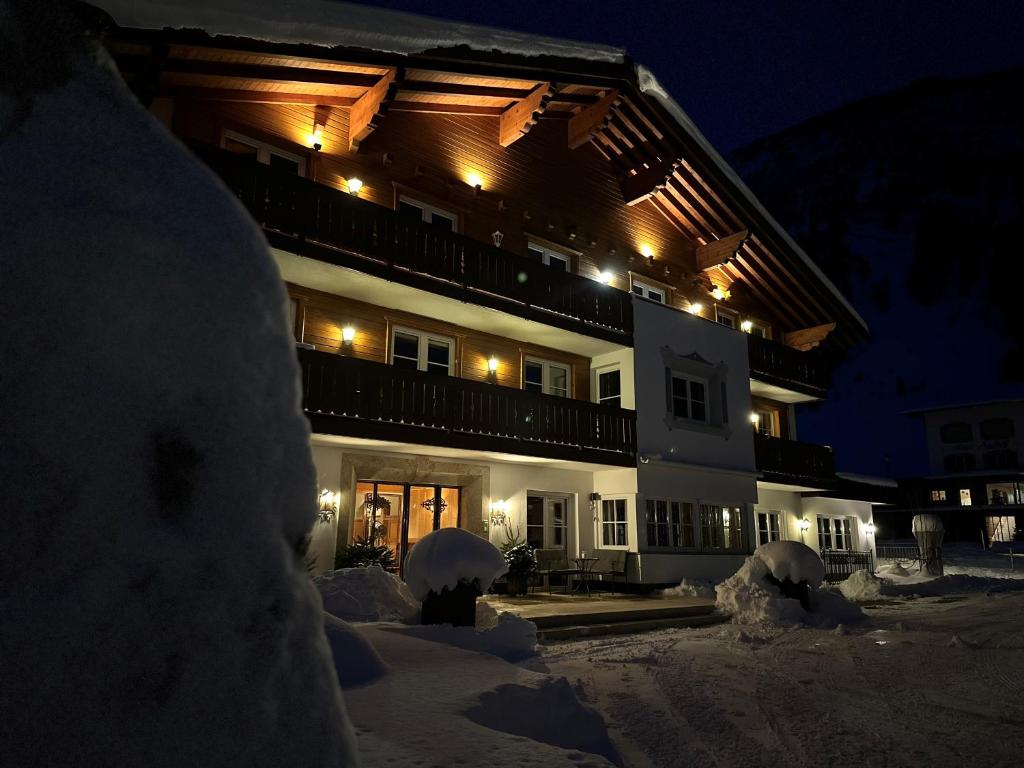 un edificio nella neve di notte di Hotel Acerina Superior a Lech am Arlberg