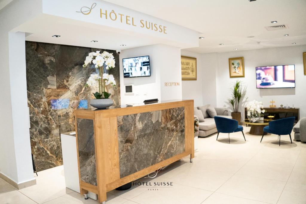 a lobby with a hotelulse sign on the wall at Hôtel Suisse Tunis in Tunis