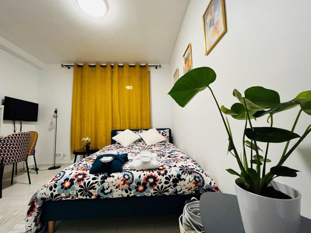 a bedroom with a bed and a potted plant at Le Pretty Spot - Studio à Bobigny in Bobigny