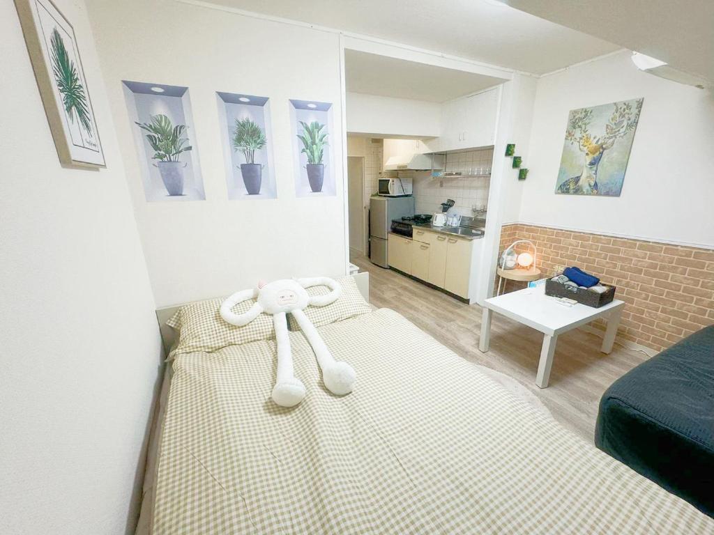 Un dormitorio con una cama con un osito de peluche. en 東新宿1分&新大久保10分 NiNi, en Tokio