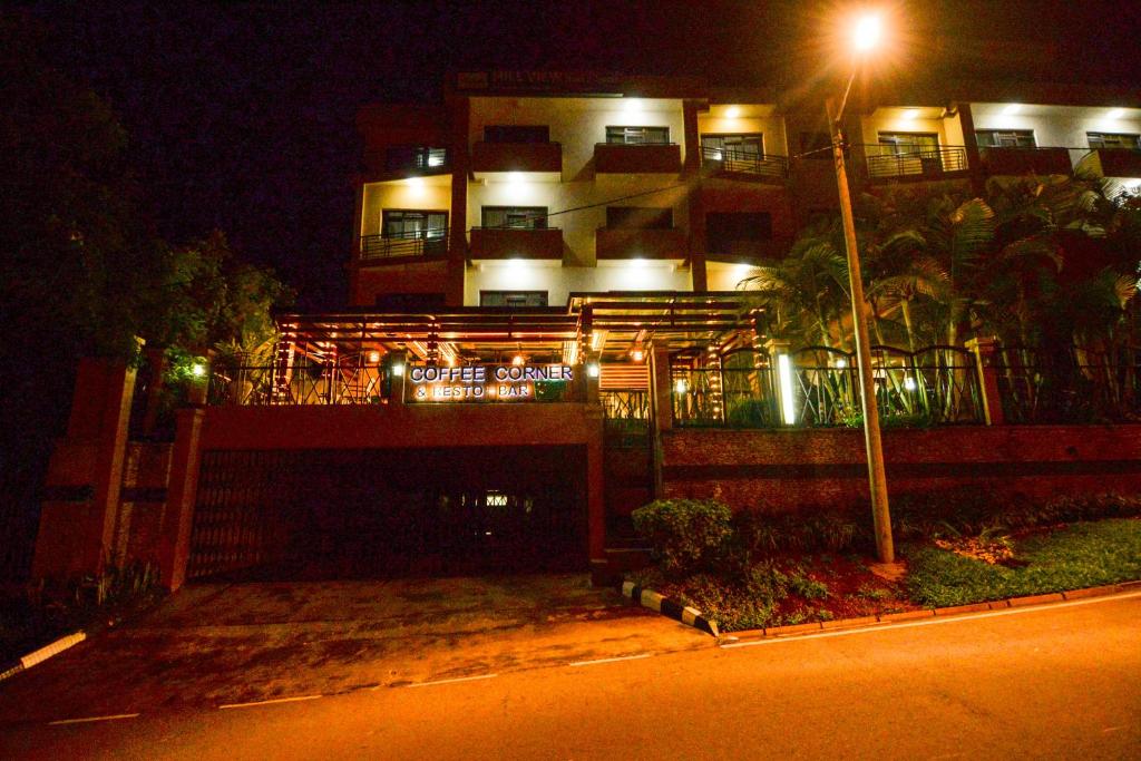 a building lit up at night with a street light at Hill View Hotel Kiyovu in Kigali