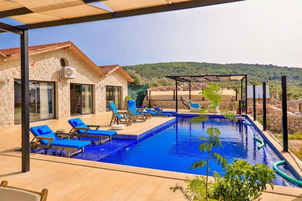 Villa con piscina con sillas azules en Villa Yaren / Kalkan, en Kas