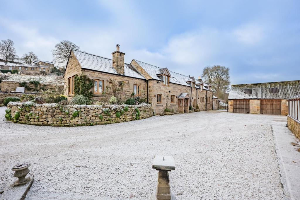 an old stone house with a large driveway at Oker Farm in Matlock