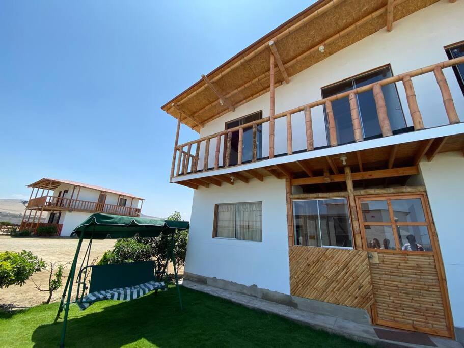 una casa con balcone e patio di Casa de campo ecológica a Huacho