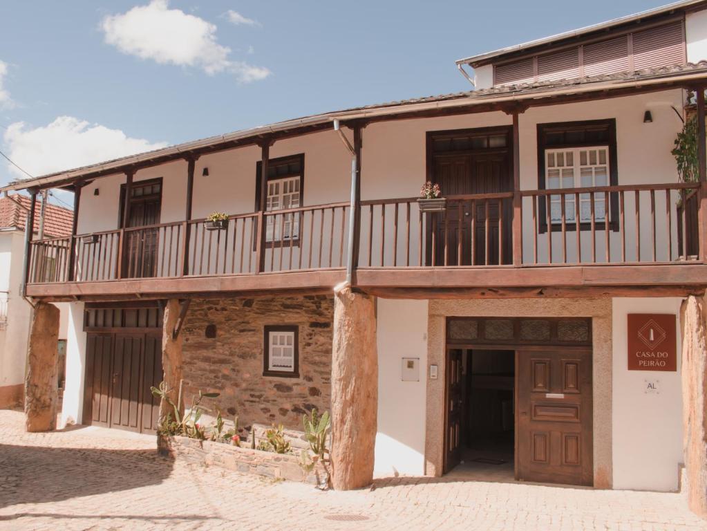 - un ancien bâtiment avec un balcon au-dessus dans l'établissement Casa Do Peirão, 