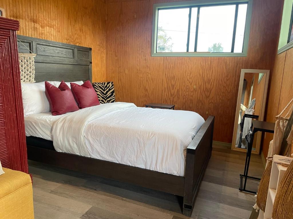 a bedroom with a bed with red pillows and a window at En Suite Flora in Dripping Springs