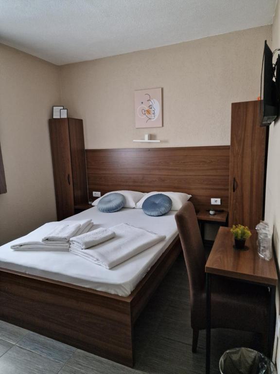 Hotel Djerdan في كرالييفو: غرفة نوم بسرير مع وسادتين وطاولة