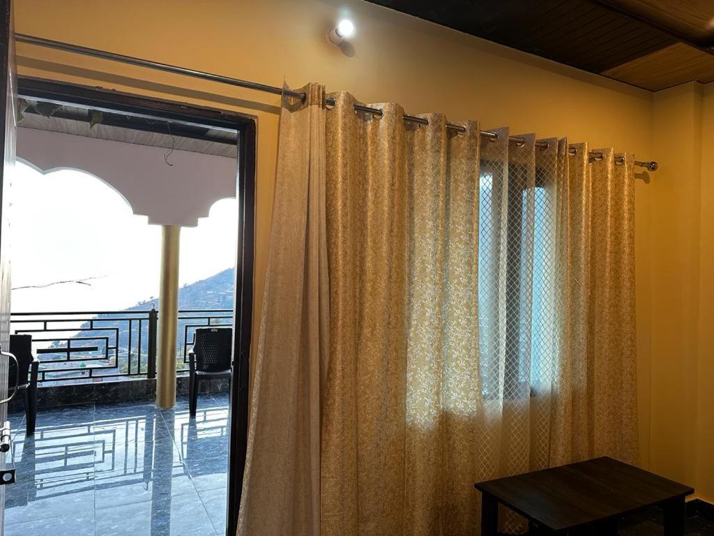 Pokój z oknem z widokiem na balkon w obiekcie BluePearlHomeStay w mieście Ukhimath