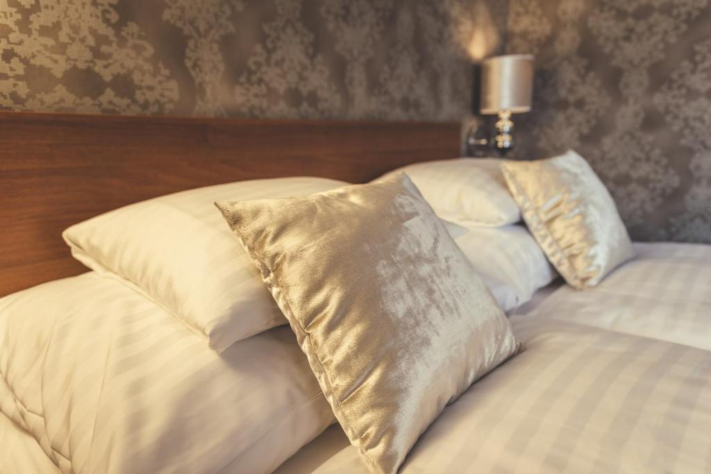 a bed with two pillows on top of it at Penzion Prinz in Valtice