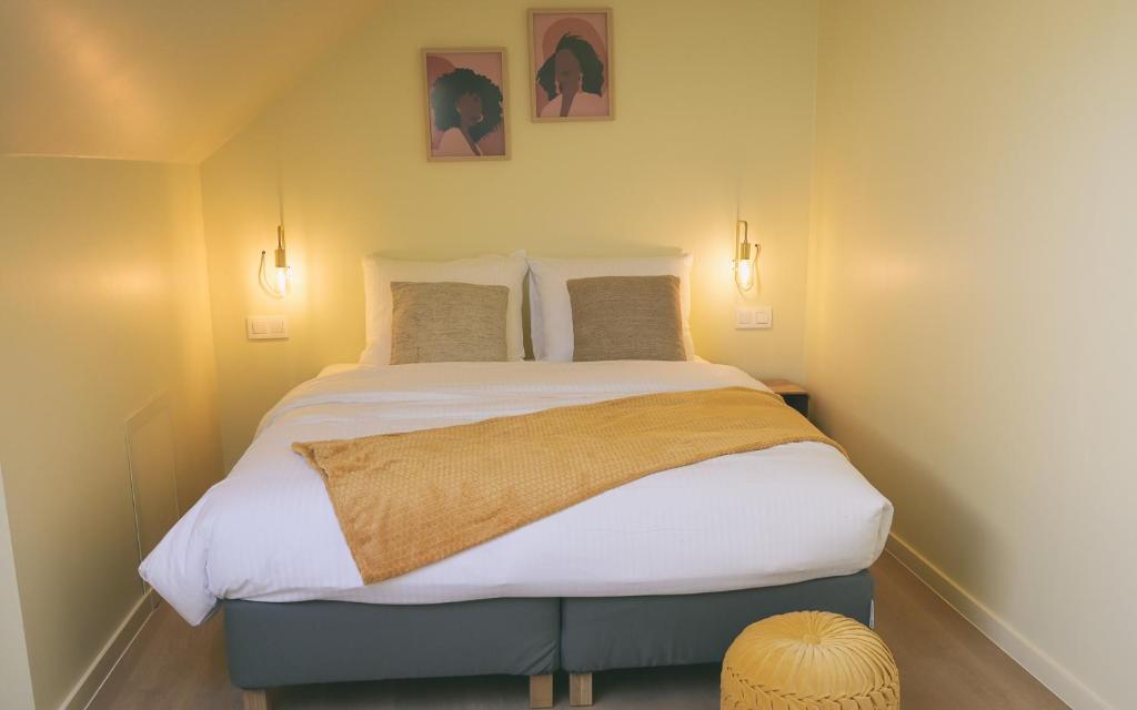 een groot bed in een kamer met twee foto's aan de muur bij The Treehouse Gistel in Gistel