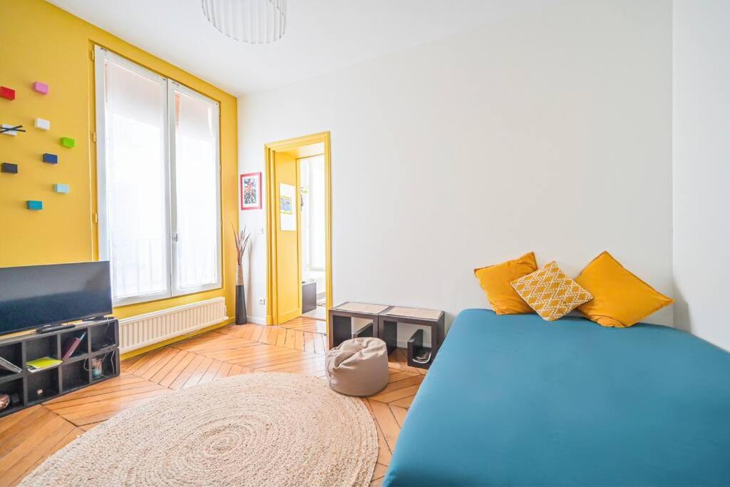 un salon avec un lit et une télévision dans l'établissement Charming Studio - Saint Apoline, à Paris