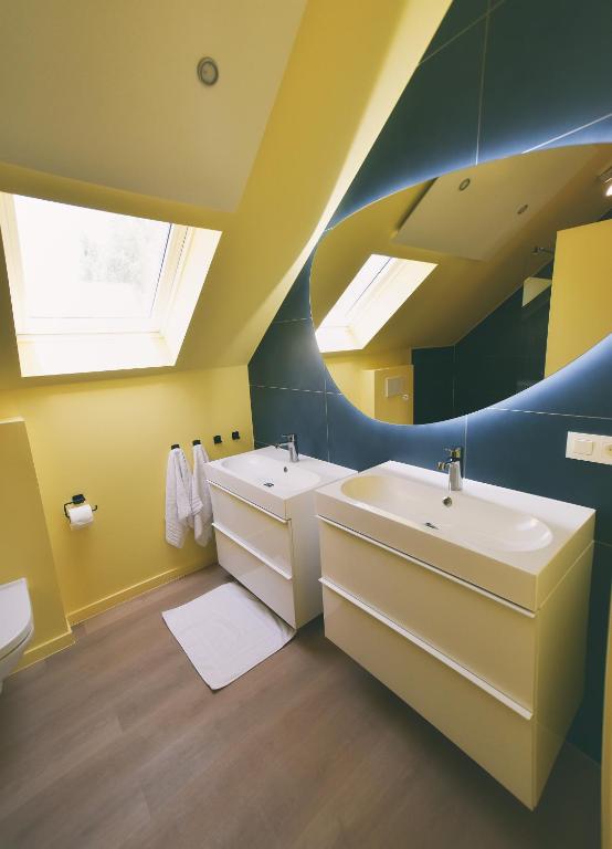 een badkamer met 2 wastafels en een spiegel bij The Treehouse Gistel in Gistel