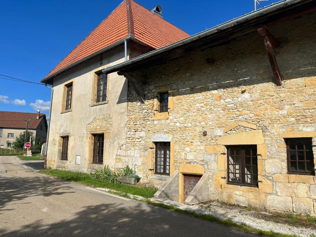 an old stone building with windows on a street at Gîte Entre Sources et Sapins 