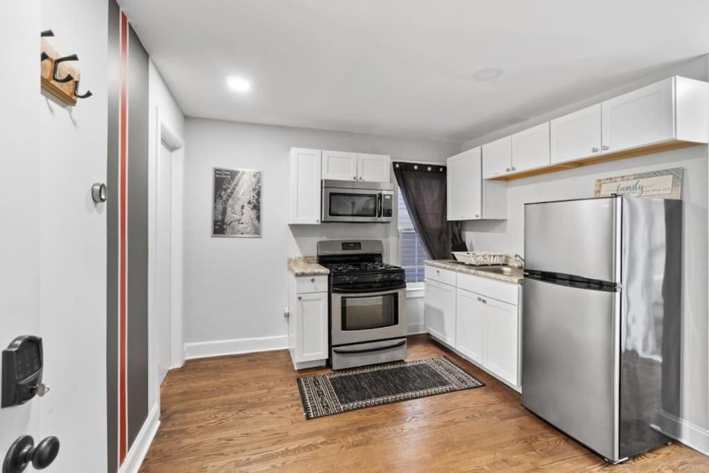 a kitchen with white cabinets and a stainless steel refrigerator at The Whimsical Estate in Bayonne