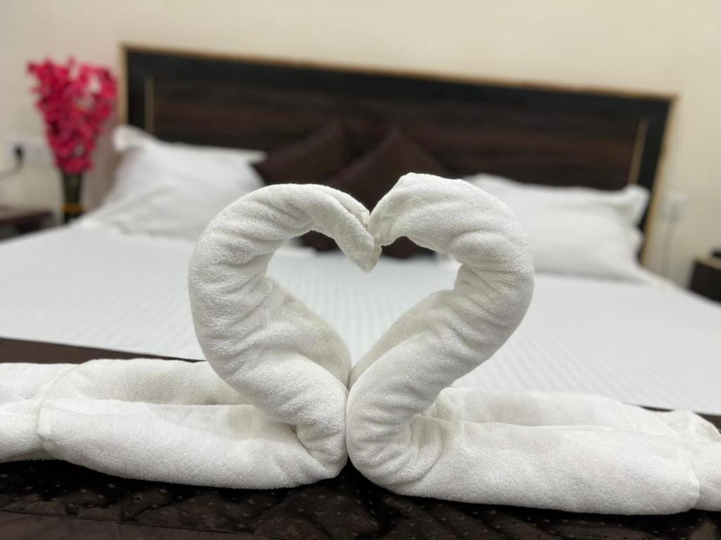 a pair of towels in the shape of a heart on a bed at Vraj waas in Mathura