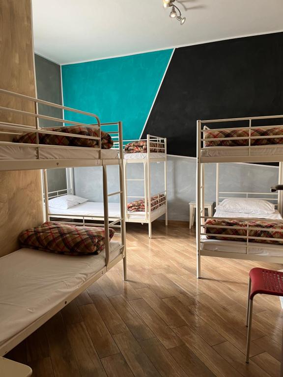 a room with three bunk beds and a blue wall at Gloria Hostel Milano in Milan