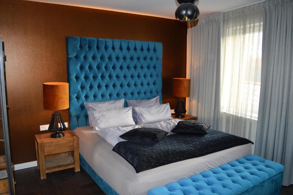 a blue bed with a blue headboard in a bedroom at Hotel Belvedere in Warnemünde
