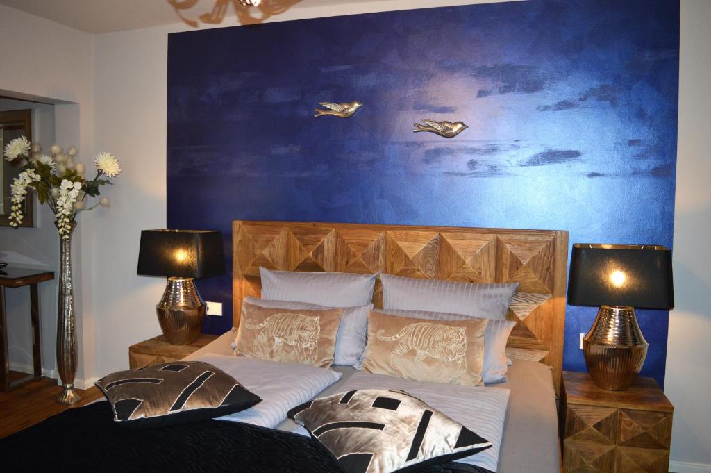 a bedroom with a bed with a blue wall at Hotel Belvedere in Warnemünde