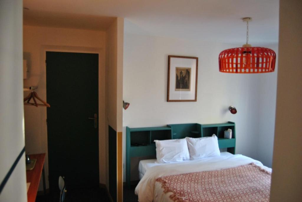 a bedroom with a bed with a green headboard at Aux Écuries Des Pres in Nogent-sur-Seine