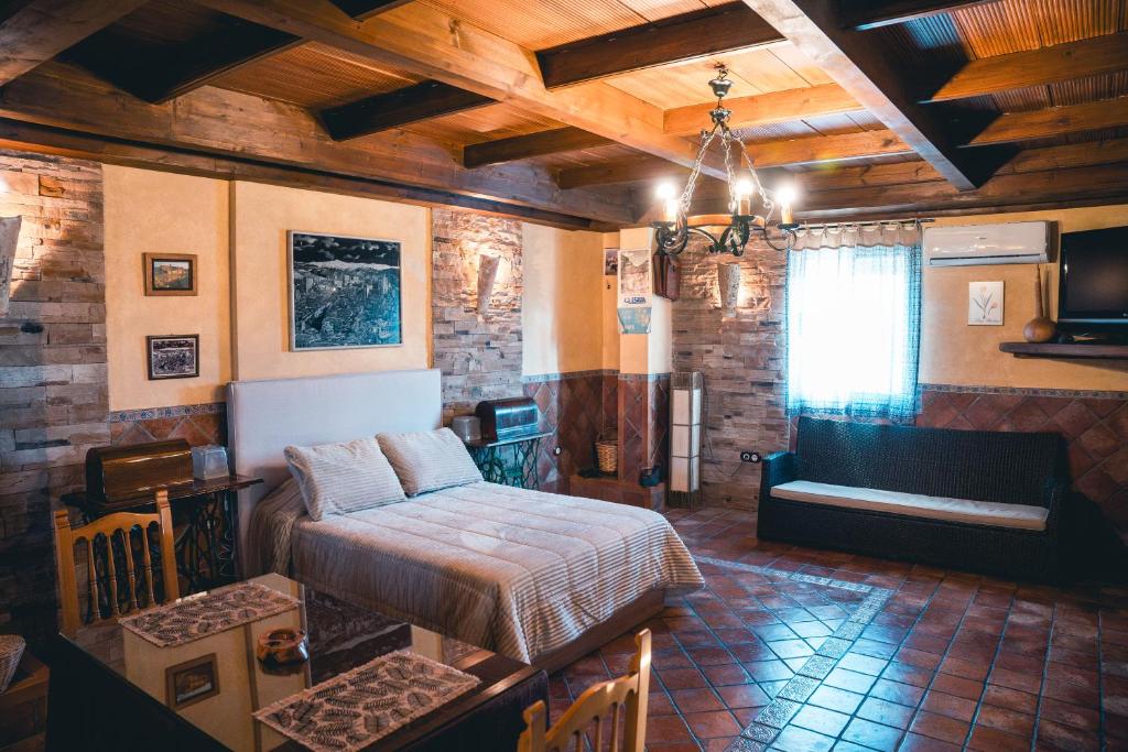 a bedroom with a bed and a couch in a room at La Casita de los Cactus in Armilla
