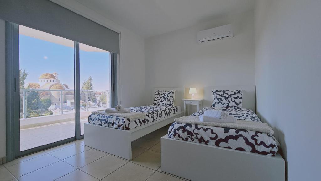 a bedroom with two beds and a large window at STAY Skyline Nest in Larnaka