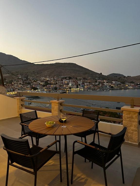 una mesa y sillas en un balcón con vistas en Serenity Suites, en Halki