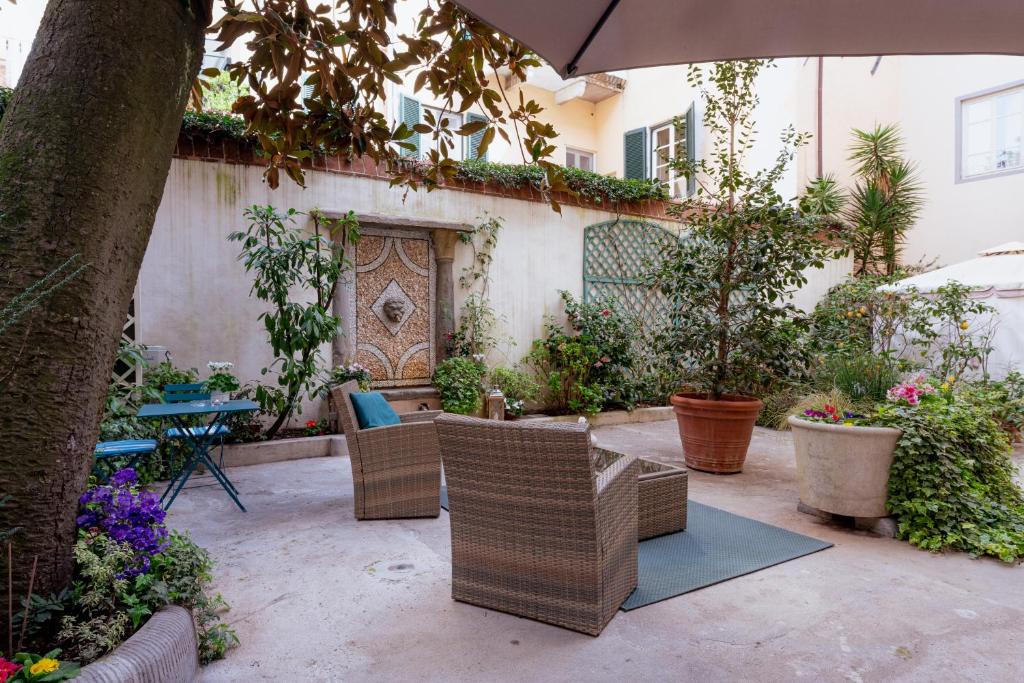 a patio with chairs and a table with an umbrella at Il Cortile di Elisa & our flats in Lucca